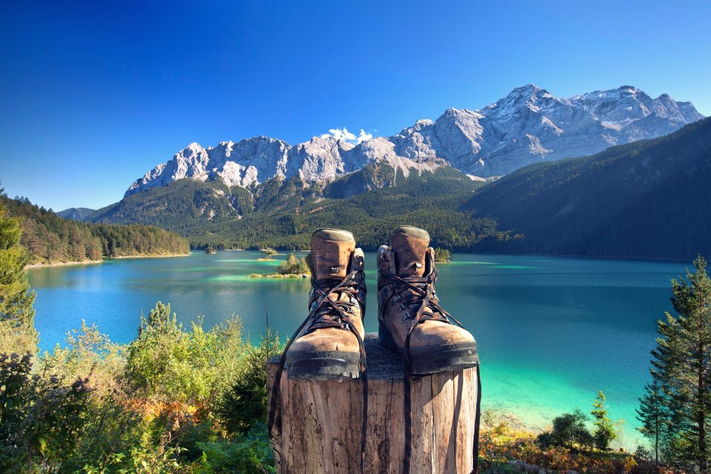 Bergschuhe mit Bergen und Meer im Hintergrund